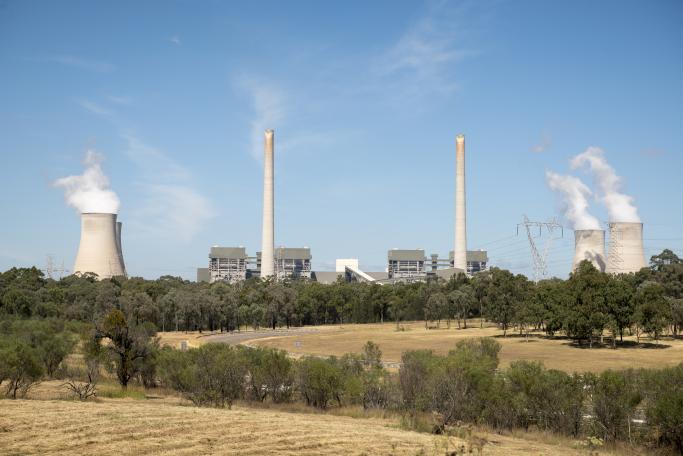 Farmland in foreground with polluting heavy industry in the background.